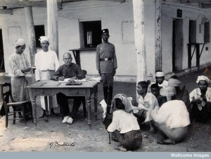 V0029680 A man sitting at a table examining passports, during a plagu